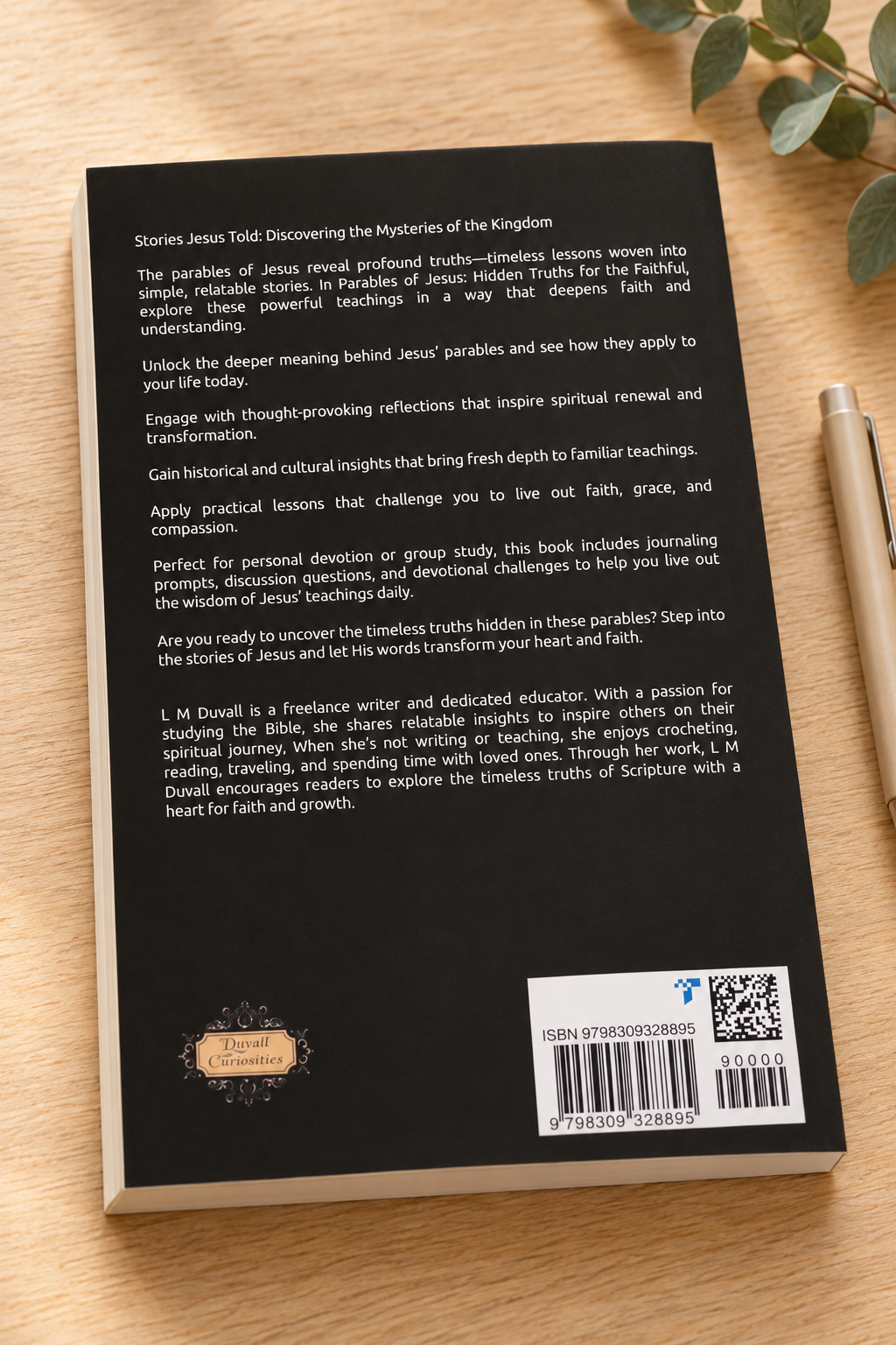 Back cover of The Parables of Jesus paperback displayed on a light oak table with subtle greenery and a neutral pen.